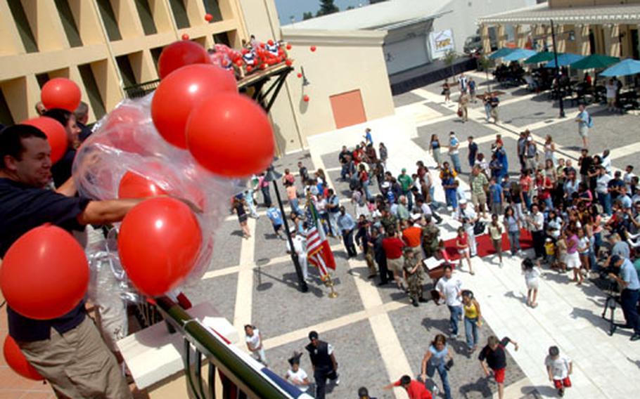 Balloons are released as the ribbon is cut and patrons rush into the new Morale, Welfare and Recreation complex at Naval Air Station Sigonella on Friday.