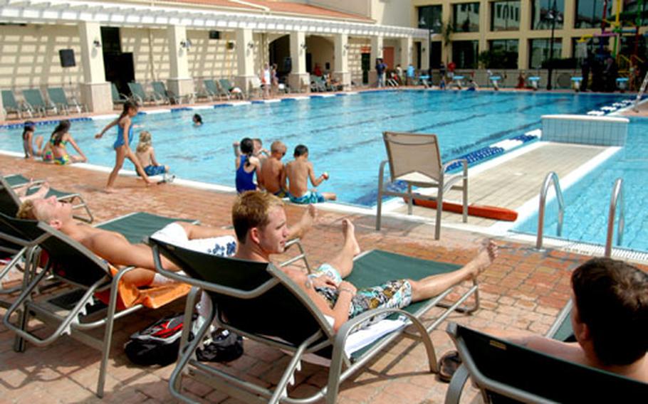 Seaman Josh McCullough, of the base dental clinic, left, sits and talks with Seaman Jonathan “Big Bear” Maenner at the new Sigonella base pool.