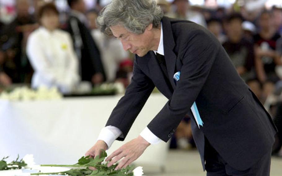 Japanese Prime Minister Junichiro Koizumi places a chrysanthemum during Thursday&#39;s ceremony at Peace Prayer Park in Itoman.