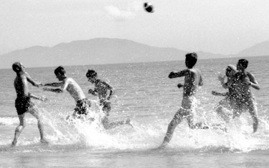 Soldiers almost ready to return to their units play football in the surf at Cam Ranh Bay.