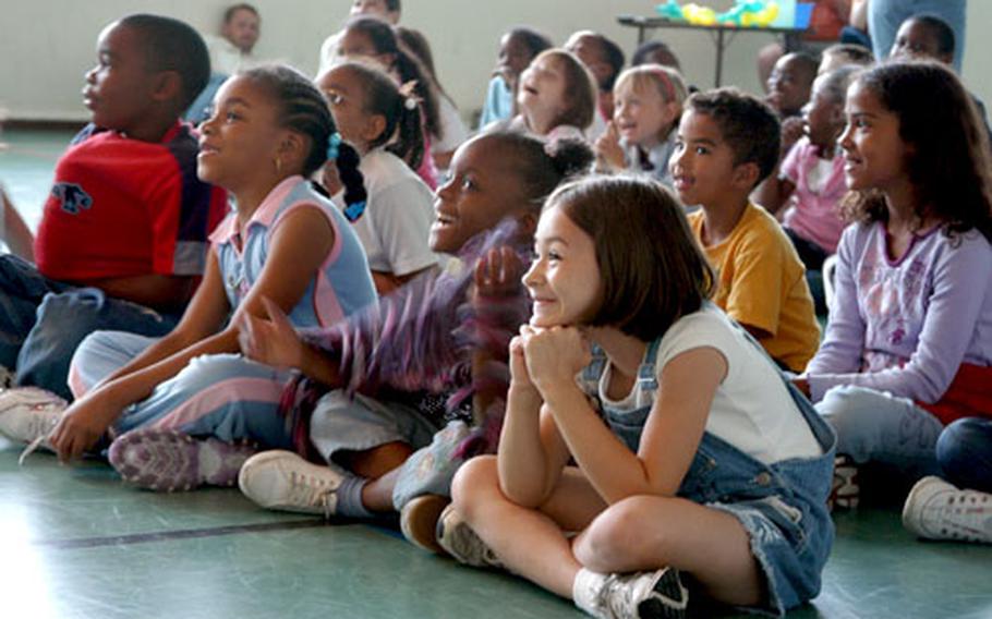 Kids get a laugh from a skit during "Stories in the Park." Cool, rainy weather moved most of the event into the elementary school gym, instead of on the grassy hill outside where it was supposed to be held.