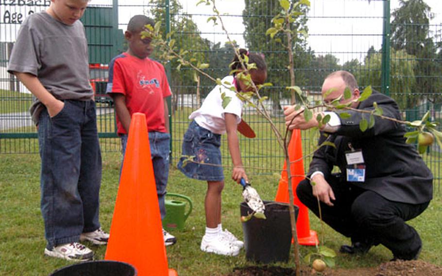 With the help of some Butzbach kids, University of Maryland&#39;s Randy McNally plants an apple tree near the elementary school at the end of "Stories in the Park."