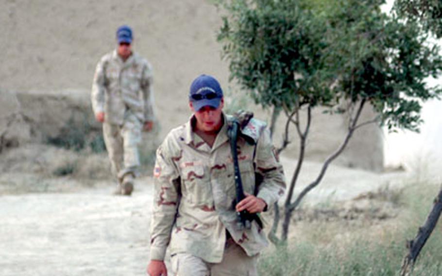 Sgt. Scott Dinse walks through a small grove of almond trees at Forward Operating Base Sweeney in Afghanistan.