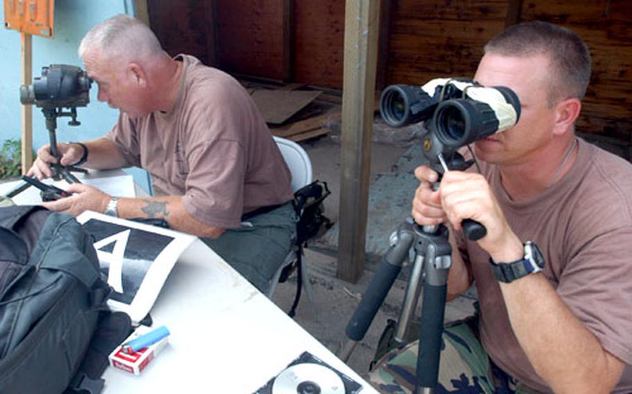 Former Army sniper Leroy Brink, left, and Staff Sgt. Jason Smith of the U.S. Army Sniper School search for trainee snipers stalking them at the Joint Security Area Mock Up Range on Friday.