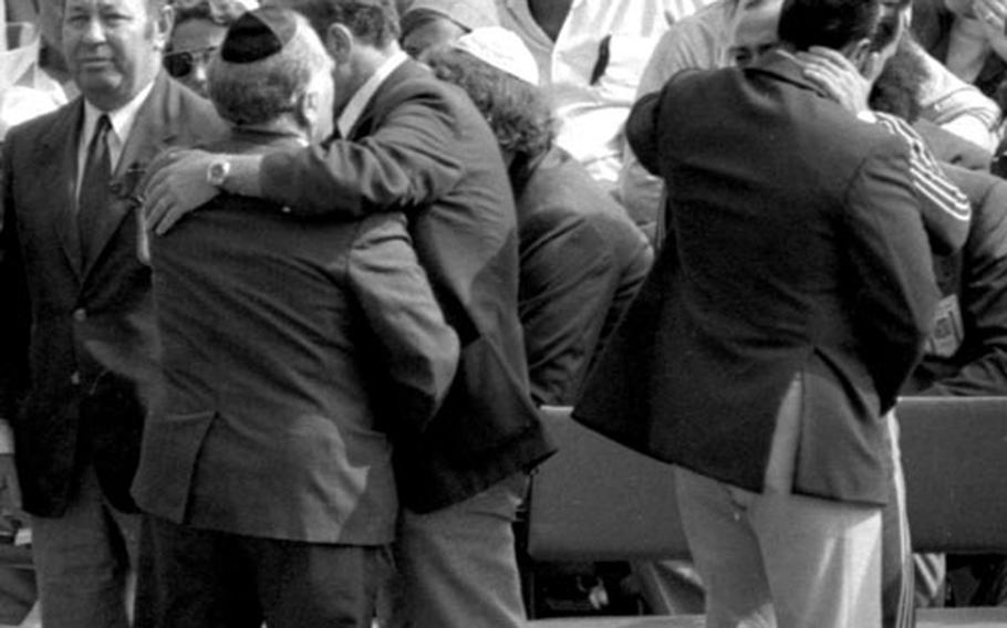 Mourners embrace before the memorial service at Olympic Stadium in Munich on September 6, 1972.