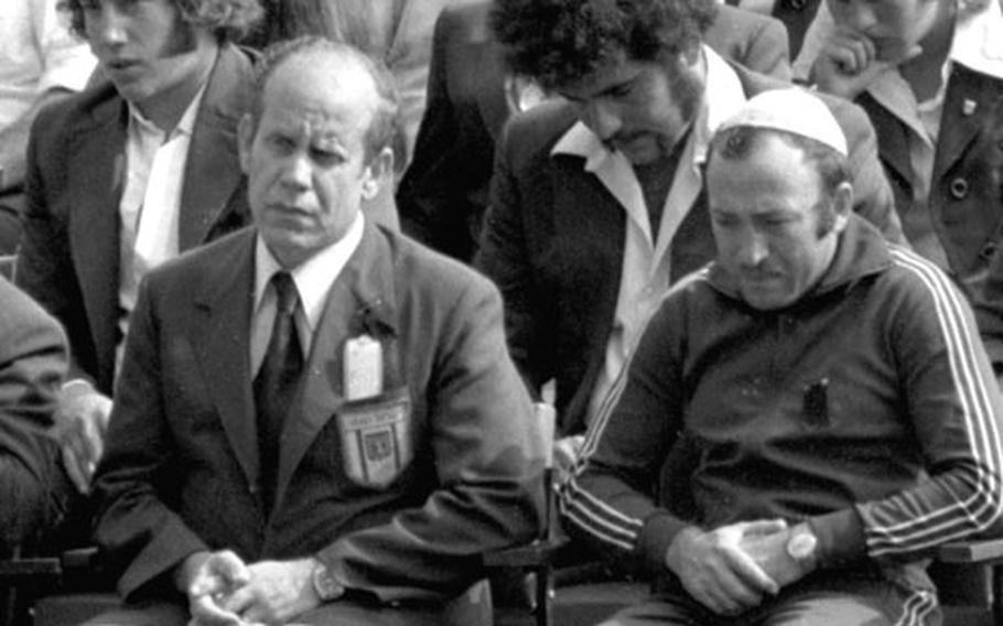 Israeli team members listen to a speaker at the memorial ceremony.