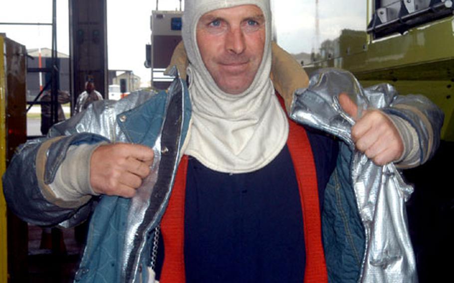 Paul Nicholls, a fire department crew chief at RAF Fairford, England, dons his gear Tuesday prior to the launch of the space shuttle Discovery. The base in western England is a designated emergency landing site in case of problems soon after launch.