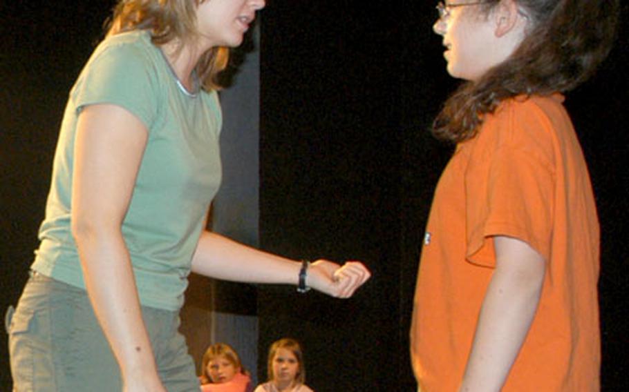 Susie Hare, left, a theater specialist for the 6th Area Support Group, instructs Isabel Greene, 12, on Wednesday during the Summer Theatre Workshop for Young People at the Kelley Theatre in Stuttgart, Germany.