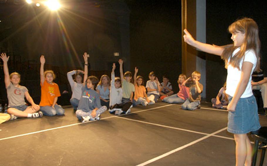 Eight-year-old Meagan Branch picks a classmate to guess which role she just performed on Wednesday during the Summer Theatre Workshop for Young People.