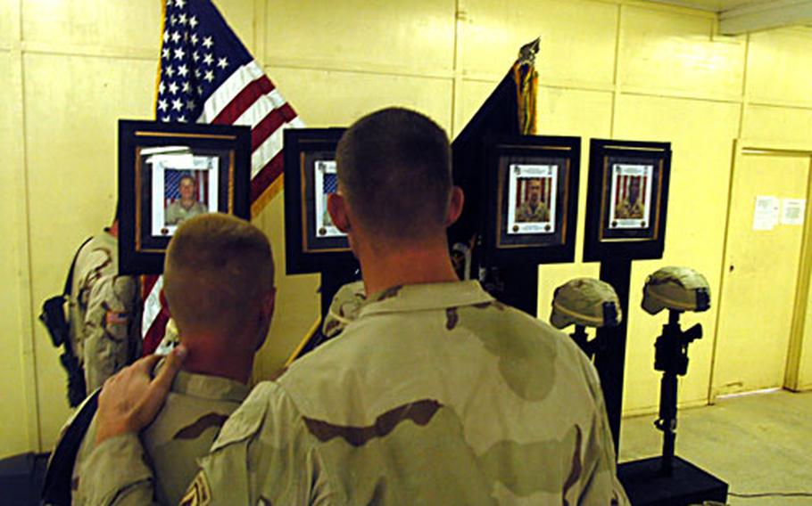 Sgt. Christopher Holbrook puts his arm on the shoulder of Sgt. Timothy Smith after a memorial service for four soldiers from Company B, 2nd Battalion (Airbrone), 503rd Infantry Regiment, killed last week by a roadside bomb.