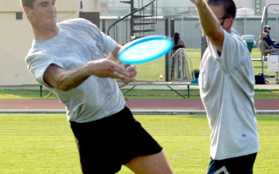 Kevin Caroon tries to toss a Frisbee past Mike Furman during a pickup game Thursday at Caserma Ederle in Vicenza, Italy. Enthusiasts on base are trying to form a recreational league.