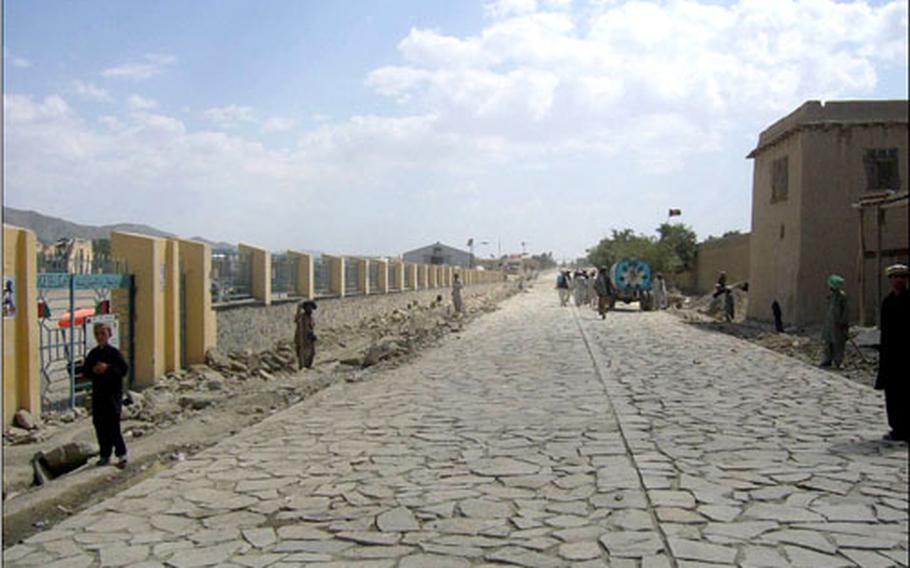 Afghan people use the new cobblestone road in Orgun-E. Coalition forces and Afghan officials celebrated the opening of the 8,200-foot road Sept. 10.