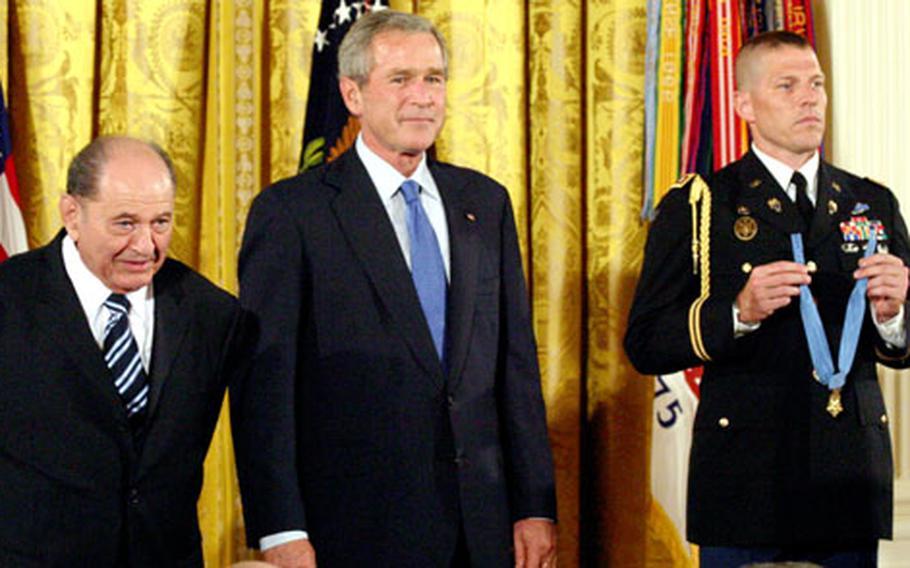 Tibor Rubin, President Bush and a military attache listen to the reading of Rubin&#39;s Medal of Honor citation.