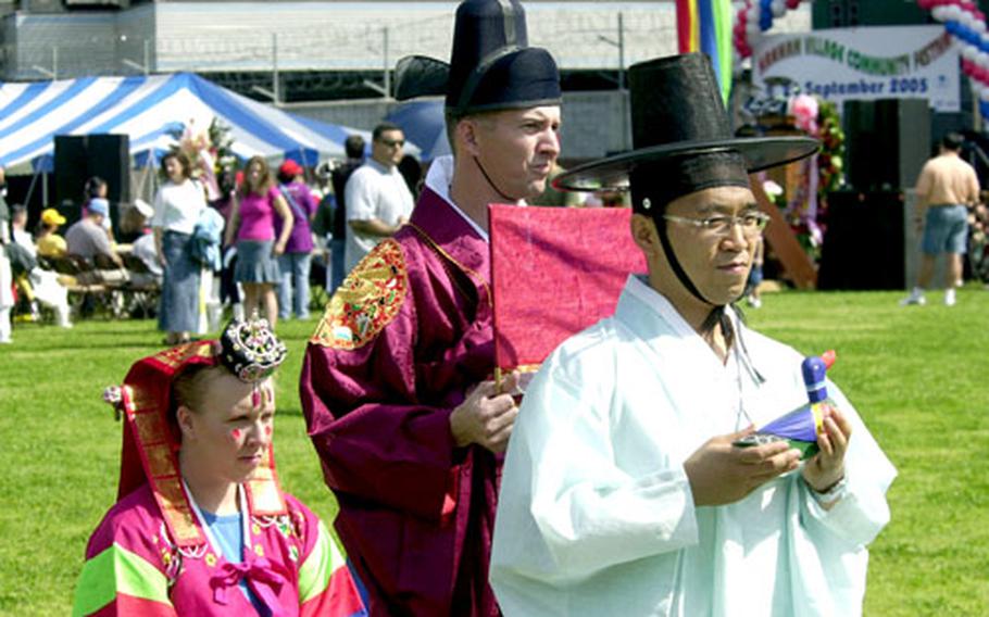 Maj. Stacie Hatten and her husband Glen participate in the re-creation of a traditional Korean wedding during the Hannam Village Community Festival on Saturday.