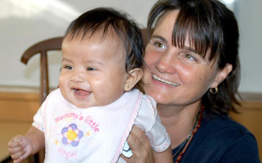 Sollars Elementary School teacher Tracy Rice holds her 4-month-old daughter, Cathy, whom she adopted this summer from the Macushi Amerindian tribe in Guyana, South America. The adoption will be finalized in November.