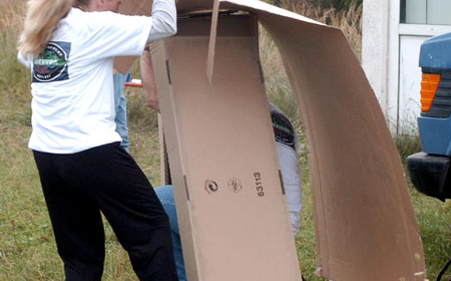 Heather Leeds and Maj. David Knellinger construct a shelter out of cardboard Wednesday in Bamberg during a "Survivor"-style competition judged by three former contestants of the reality TV show.