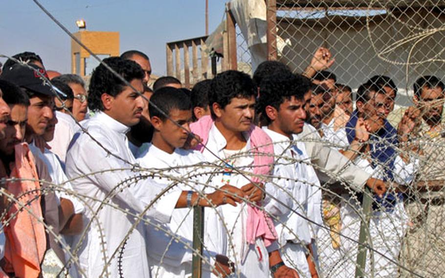 Prisoners wait to be released from Abu Ghraib prison on Saturday.