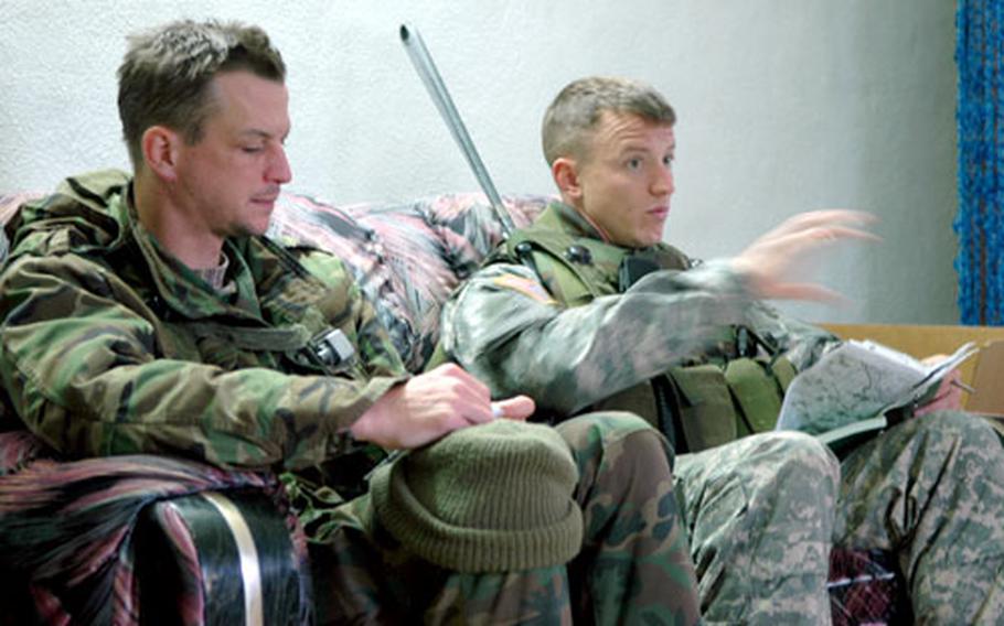 Capt. Chris Kuzio, right, and his translator talk business with "Iraqi officials" during a training exercise last week at Hohenfels, Germany.