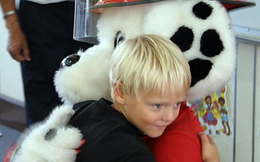 First-grader Kyle Hollinger says goodbye to Sparky the Fire Dog with a hug Friday after attending the fire-safety awareness class taught by the Commander, Naval Forces Japan Regional Fire Department. The class, at Naval Air Facility Atsugi’s Shirley Lanham Elementary School, prepped the children for National Fire Prevention Week.