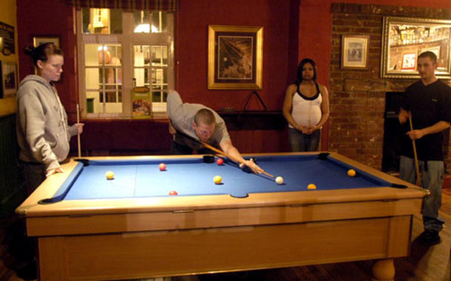 Jason Daffern makes a shot while playing eight-ball billiards at the Bird in Hand pub near RAF Mildenhall recently. With Daffern are, from left, wife Jen, and Rosemary and Philip Harville.