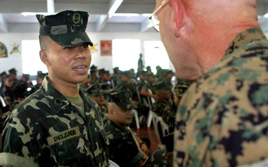 U.S. Marine Sgt. Maj. James R. McKay, right, greets Philippine Marine Sgt. Jonathan S. Delgado during the opening ceremony for a bilateral training evolution taking place in the Philippines.