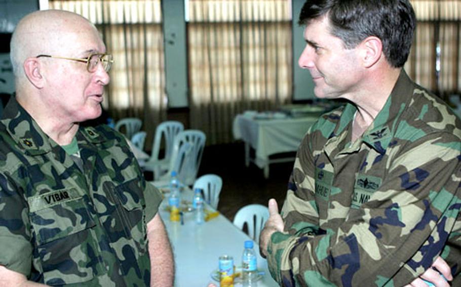 U.S. Navy Capt. Mark A. Donahue, right, the commodore of Amphibious Squadron1-11, and Philippine Marine Maj. Bon Vibar have a discussion after the opening ceremony.