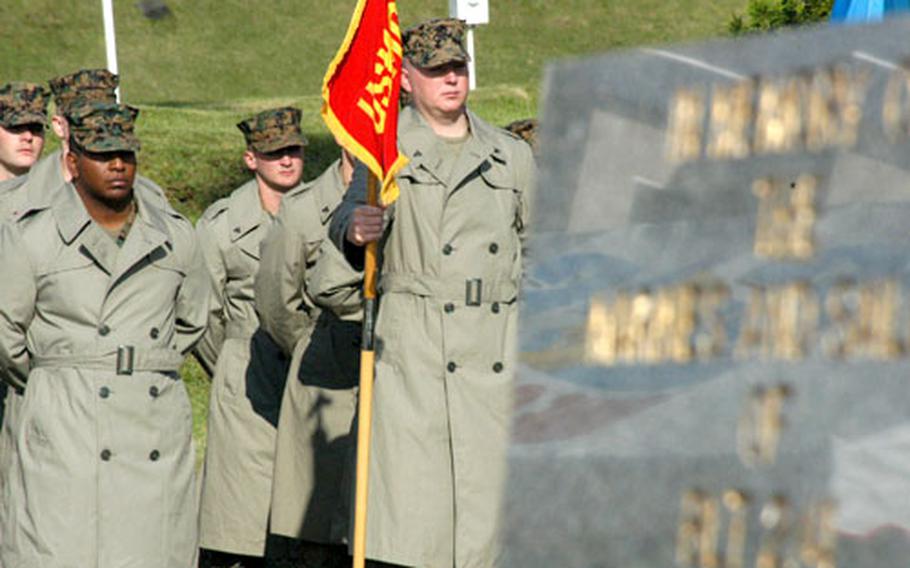 Marines from Camp Fuji&#39;s Combined Arms Training Center stand solemnly near the fire memorial marker at Wednesday&#39;s annual ceremony at the base flagpole. The observance marked the Oct. 19, 1979, blaze that killed 13 Marines and injured dozens more.