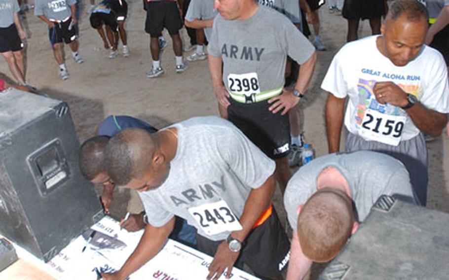 Runners sign a banner before the Big Easy 5K run Oct. 16 at Forward Operating Base Speicher near Tikrit, Iraq.