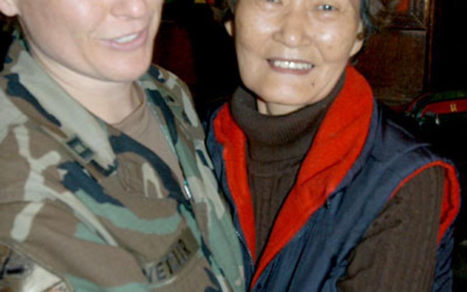 Camp Kyle&#39;s last commander, Capt. Bridget Wetzler, gets a goodbye hug from Edee Wa club bartender Kim Yong-Hui on Wednesday.