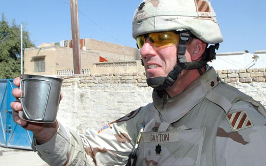 Lt. Col. Jamie Gayton samples water from a $100,000 water purification system installed at a local school. "It tastes good," he said.