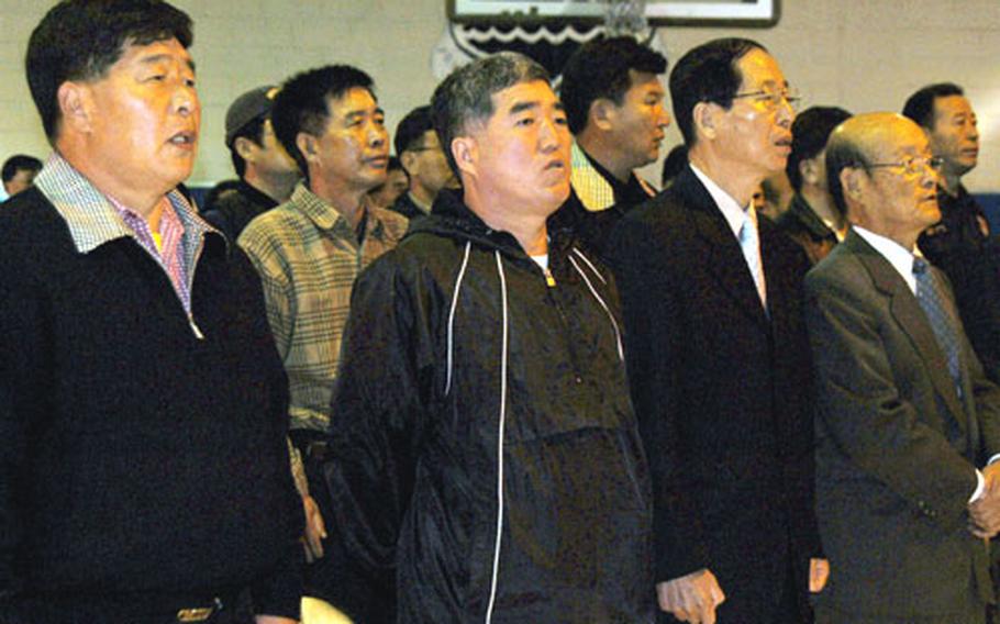 South Koreans who lost their jobs when Camp Colbern closed sing their national anthem Wednesday during a ceremony at Colbern recognizing their years of service. The camp closed in October, and the U.S. soldiers there moved to Camp Stanley near Uijeongbu, South Korea.