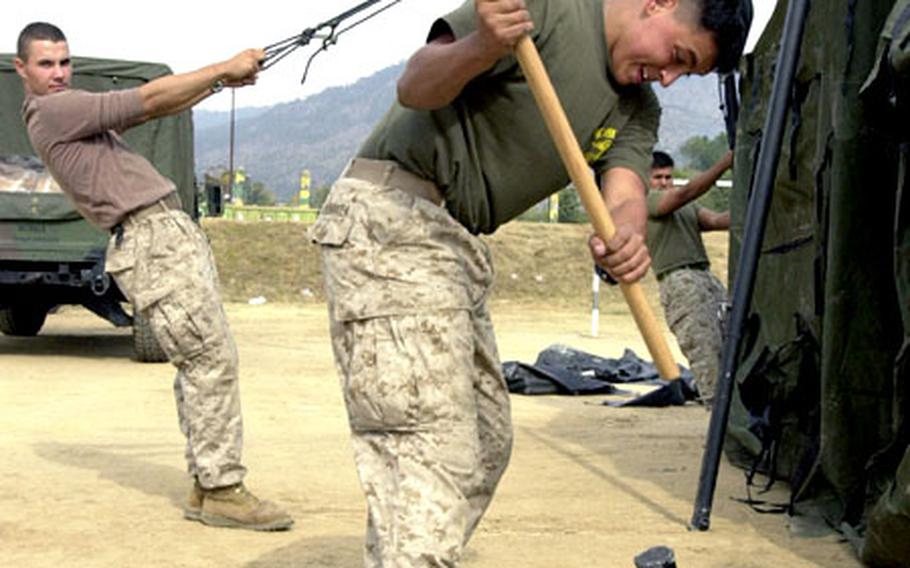 Lance Cpl. Daniel Mendoza, an embarkation specialist from 3rd Marine Logistics Group, pounds a stake into the ground at the site where the detachment from III Marine Expeditionary Force from Okinawa will set up shop. More than 200 Marines and sailors, including the Bravo Surgical Company from 3rd Medical Battalion, are in Pakistan to provide medical and humanitarian relief to earthquake survivors.