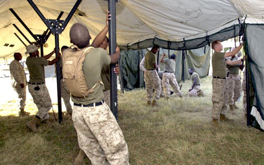 Sailors from 3rd Medical Battalion on Okinawa raise hospital tents at their site in Shinkiari, Pakistan, Monday afternoon.