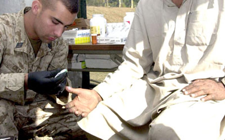 Muhammed Anvir, a local of Shinkiari, Pakistan, has antiobiotic cream applied to his thumb before it&#39;s bandaged by Seaman Jonathan Casale, a corpsman with Okinawa&#39;s 3rd Medical Battalion. Anvir, who smashed his thumb with a hammer, was the first patient to be seen at the site where the Marines and sailors from III Marine Expeditionary Force have set up in Shinkiari.