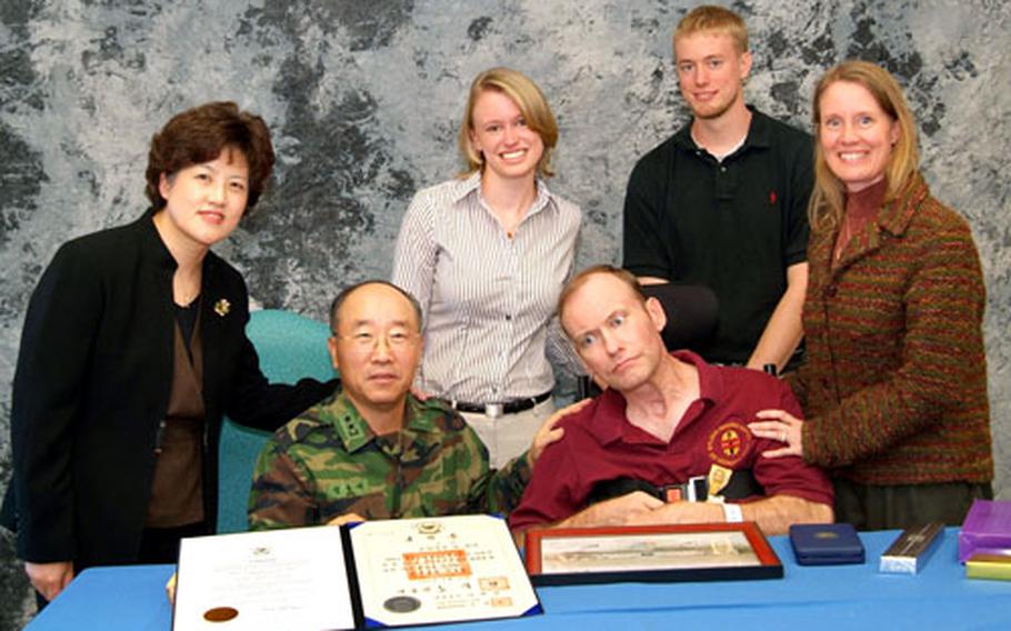 South Korean Maj. Gen. Chung Joong-suk presented U.S. Army Col. Bryan D. Keifer with a medal from the Korean military for Keifer’s service on the peninsula. Earlier this year, Keifer suffered neurological damage after an angioplasty procedure. Standing from left are Chung’s wife Kim Hong-won; Keifer’s children Christie and Zach; and Keifer’s wife Parrie.