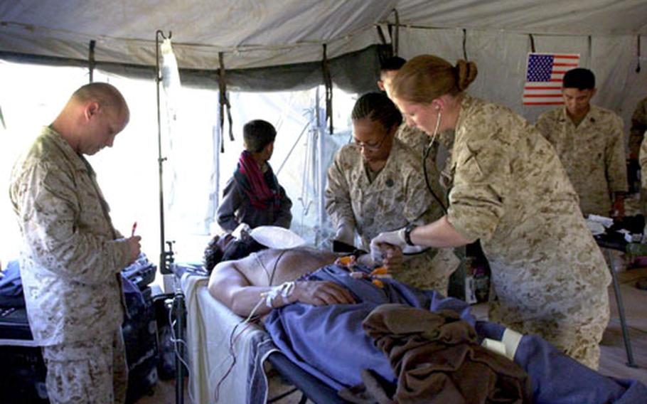 Navy nurses Lt. j.g. Brookes Englebert, right, and Lt. Robert Barrett, left, and Petty Officer 3rd Class Althea Caraballo tend to Muhammad Siab Khan Thursday in their emergency room tent in Shinkiari, Pakistan. Siab Khan was suffering from acute coronary syndrome and was later transferred to a local hospital for further care.