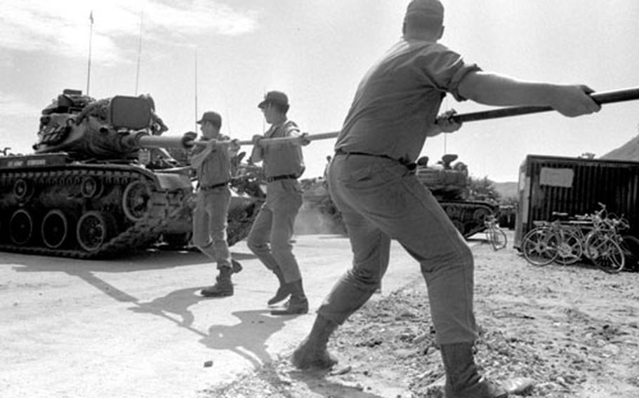 Cleaning the barrel of a tank's gun at Camp Casey, South Korea, in 1975.