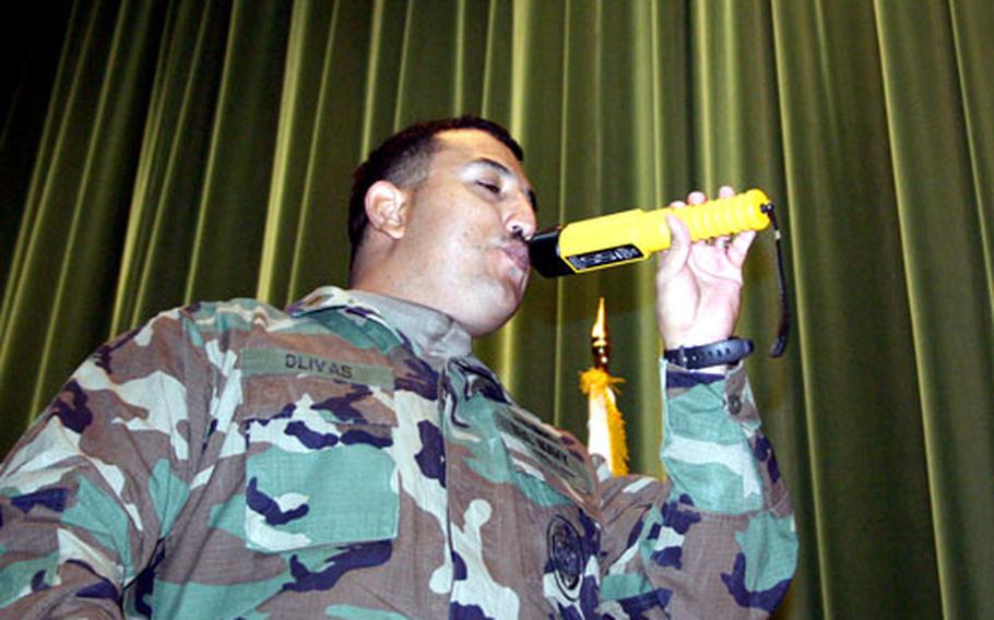 Ensign Shawn Olivas, with security at Naval Support Activity Naples, Italy, demonstrates how security forces can test a driver’s blood alcohol level by using the AlcoBlow, a wand that can detect the presence of alcohol on someone’s breath and in the air.