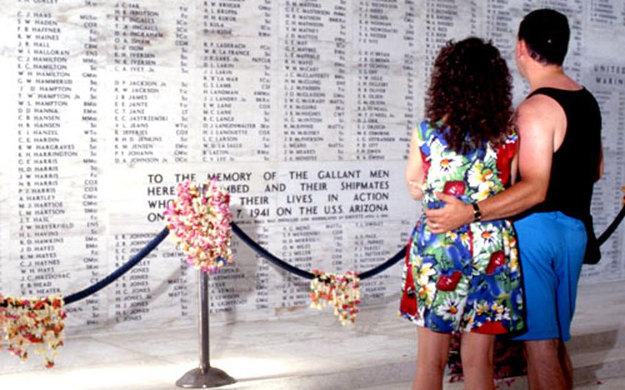 Visitors to the Arizona Memorial look at the wall of names.