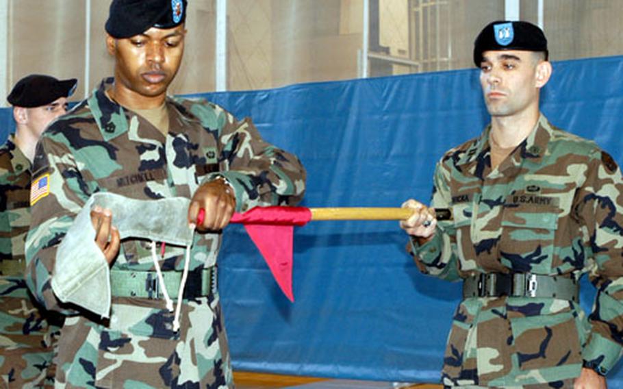 First Sgt. Rahsan Mitchell, front left, wraps up the colors of the 65th Ordnance Company Tuesday while company commander Capt. Joseph Borovicka holds the flag during the company&#39;s inactivation ceremony at Camp Casey, South Korea.