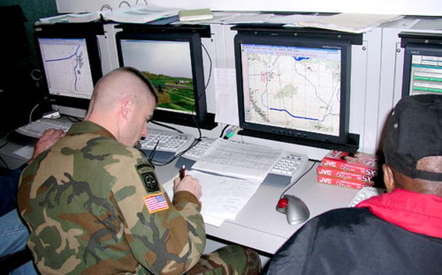 Maj. John M. Hinck, operations officer with the 1st Batallion, 2nd Aviation Regiment, helps control a mock combat mission using the AVCAT simulator.