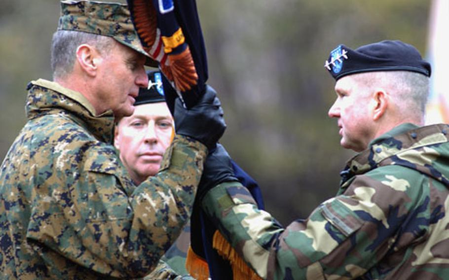 Outgoing U.S. Army Europe commander Gen. B.B. Bell, right, hands over the USAREUR colors to Gen. James L. Jones, commander of U.S. European Command as incoming USAREUR commander Gen. David D. McKiernan watches at center.