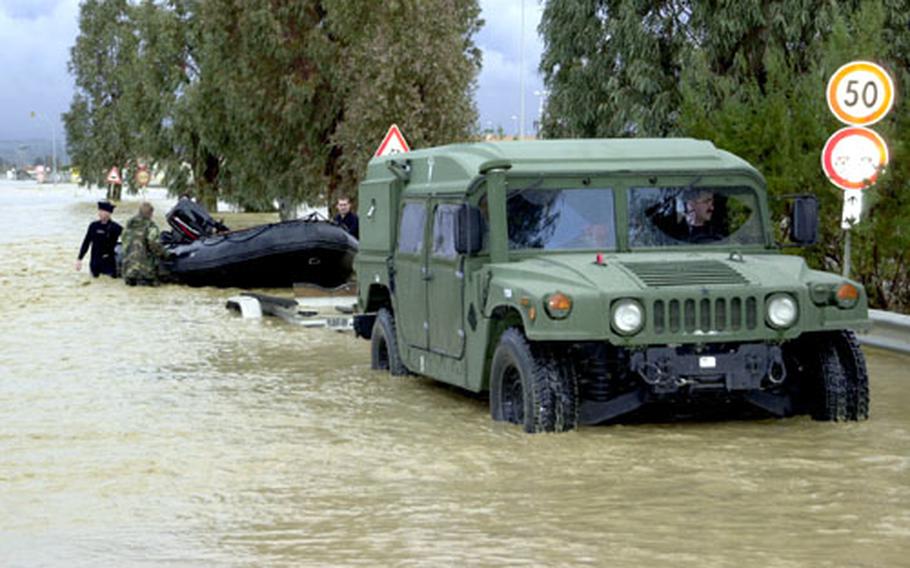 Members of Sigonella’s Explosive Ordnance Disposal Mobile Unit Eight trailer their zodiac pontoon boat following an initial exploration of the Marinai housing area.