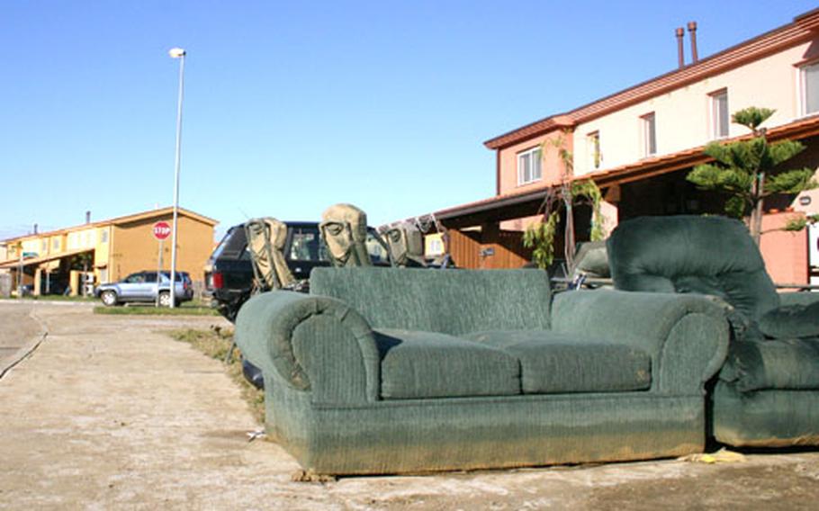 Flood-damaged couches await trash pickup Monday at the Maranai base housing complex at Naval Air Station Sigonella.