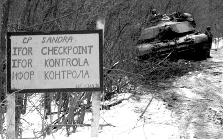 An American M1A1 Abrams tank of the 1st Armored Division guards check point Sandra on IFOR route Mississippi on the zone of separation in February, 1996.