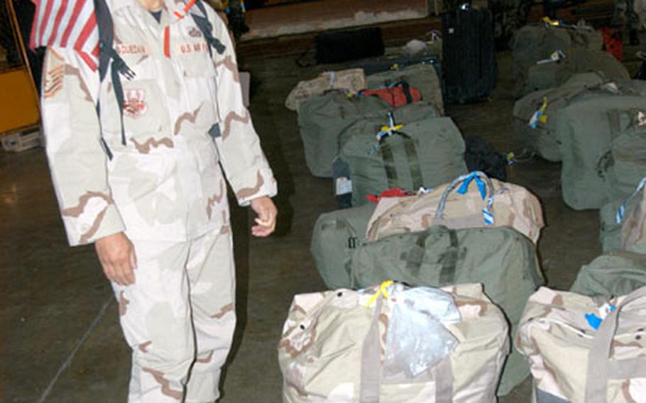 Master Sgt. Irwin Raquedan, a heating, ventilation, and air-conditioning shop superintendent with 35th Civil Engineer Squadron at Misawa Air Base, Japan, looks through a sea of bags after returning Wednesday night.