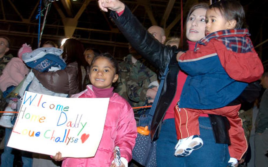 Marie Terrell, with kids Rashaun, 16 months, and Challyse, six, spots her husband, Tech. Sgt. Ramont Terrell, in the long line of airmen who filtered into Hangar 949 Monday night at Misawa Air Base, Japan. They were returning from a 4½-month Aerospace Expeditionary Force deployment. Terrell, of the 35th Communications Squadron, was deployed to Qatar. Marie Terrell said to see her husband was “like going on a first date all over again.”