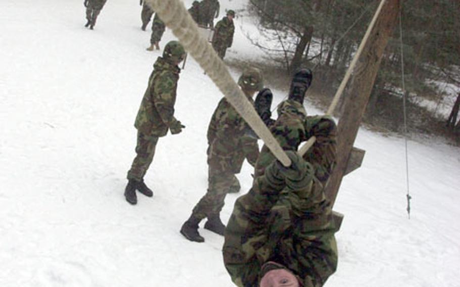 A 191st Ordinance Battalion soldier crawls along a rope on the obstacle course at Grafenwöhr.