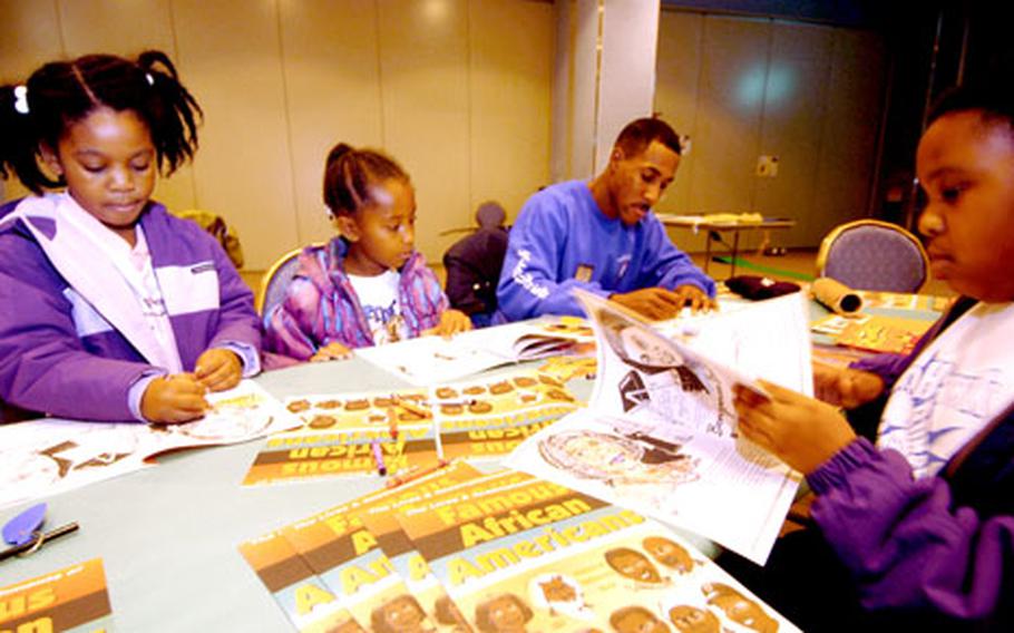 Sgt. Eric Schmidt colors with Caasi Wynn, Briana Eure, Alexis Varber and her sister Kiana Varner at the youth center at Yokota Air Base, Japan, on Saturday during Heritage Day, a celebration of black history.