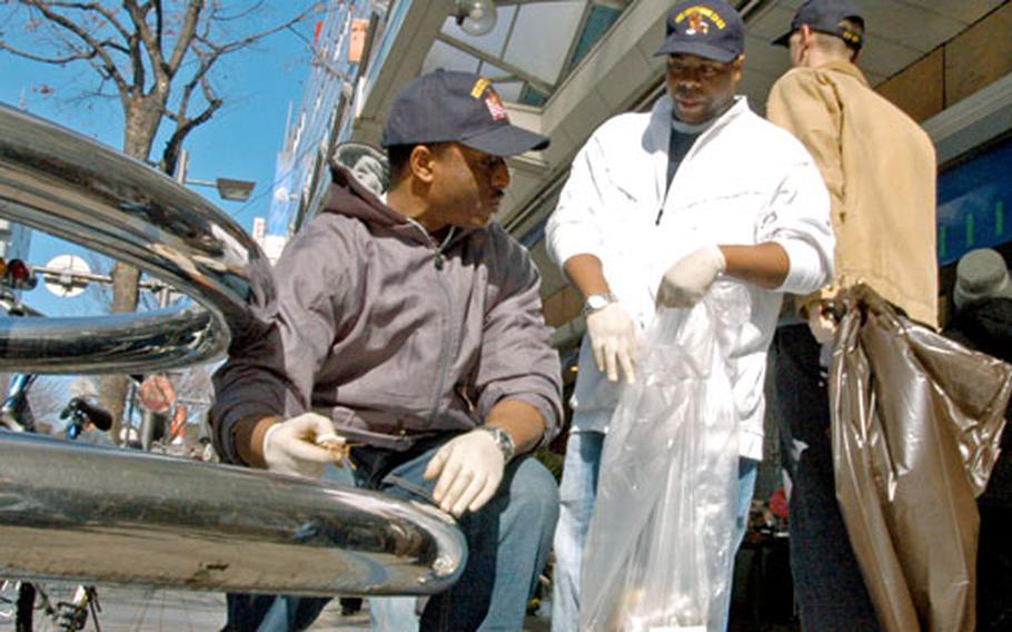 Petty Officers 3rd Class Hamzza Moore and Jarvis Robertson of the USS Kitty Hawk were part of a 90-volunteer clean-up effort in Yokosuka, Japan, on Friday.